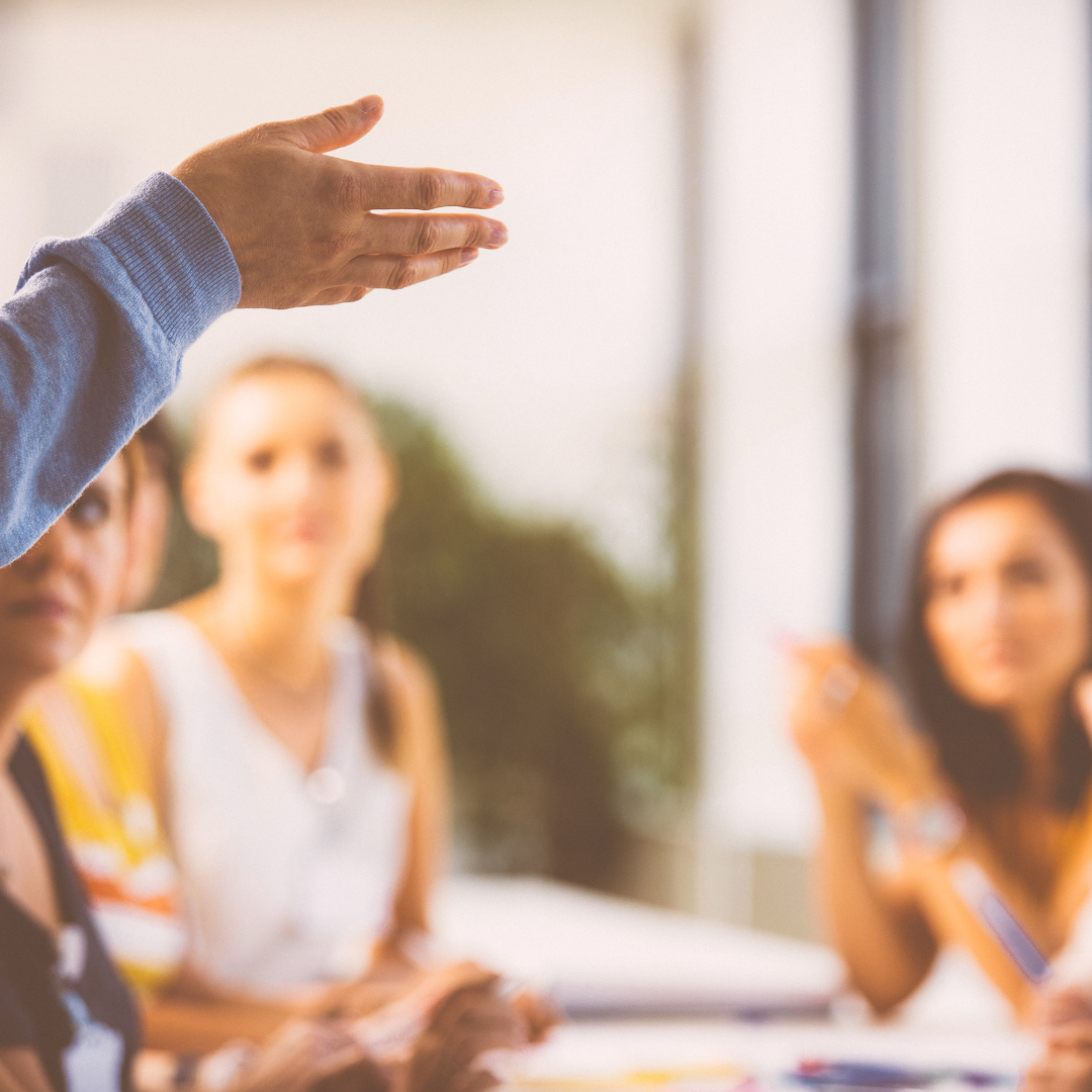 Eine Teilnehmerin spricht, vier andere hören aufmerksam zu – intensive Diskussion im Kurs.