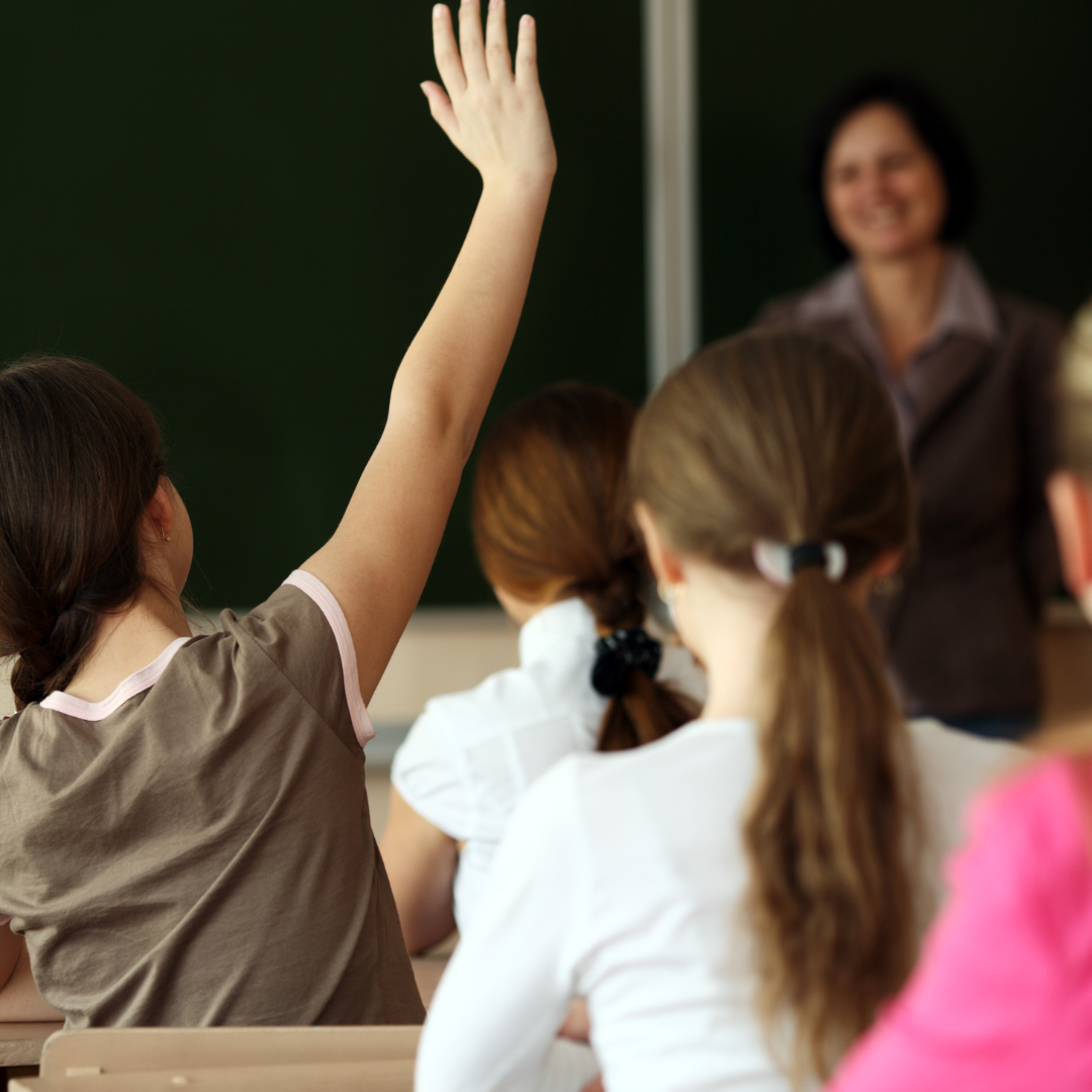 Schülerin hebt Hand im Religionsunterricht – Kurs für Lehrkräfte in der kirchlichen Bildung